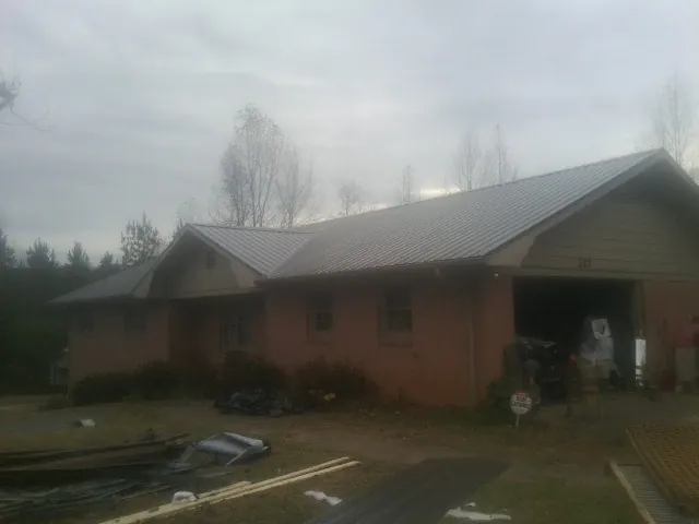 Gray metal roof on a stucco house with an attached garage in Alger