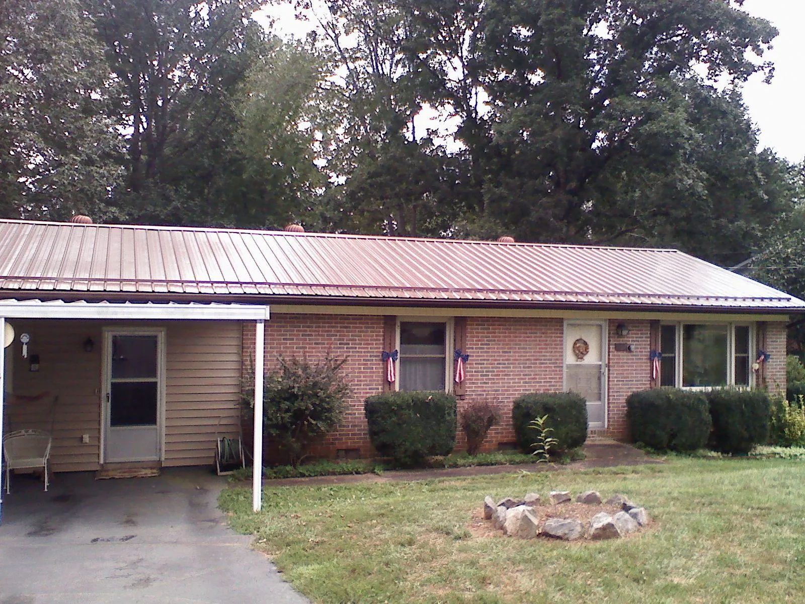 Bronze metal roof and carport on a brick ranch home — Roof Repair work by our crew in Alger